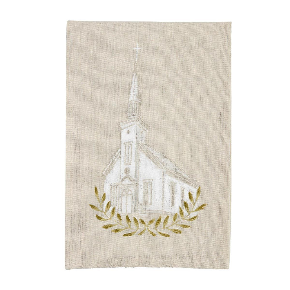 A square beige linen tea towel featuring a white line-art illustration of a church with a steeple and cross, framed by a gold embroidered laurel wreath at the bottom.