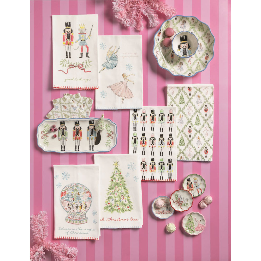Collection of Christmas-themed tableware and decor items on a pink striped background
