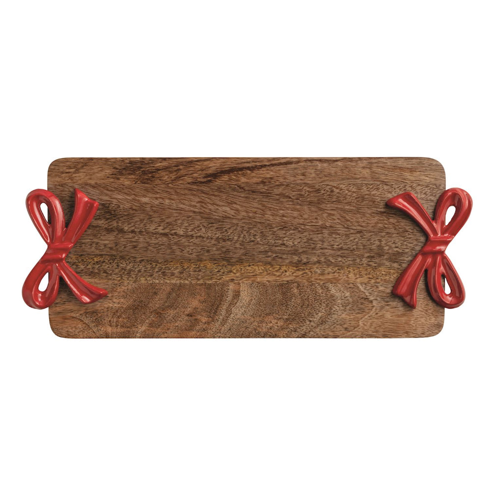 Wooden serving board with red metal handles ribbons on a white background.