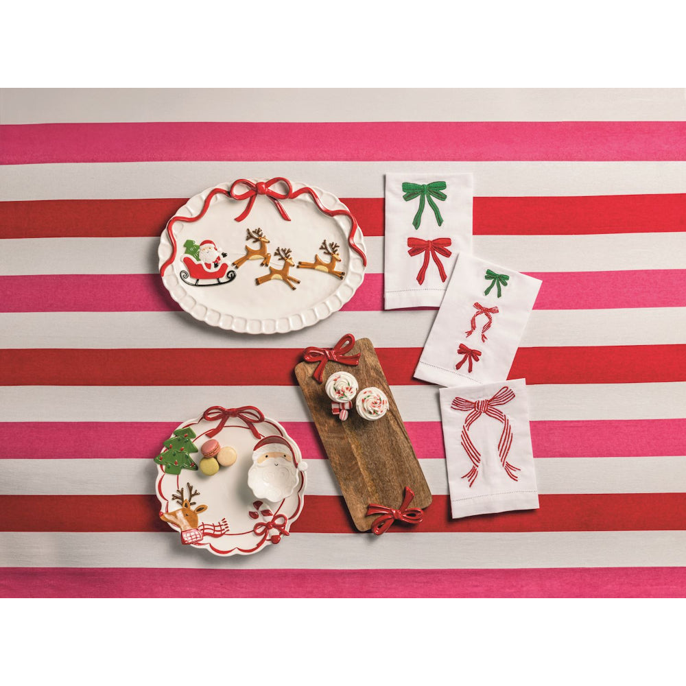 Decorative plates and towels with festive designs on a red and white striped background.