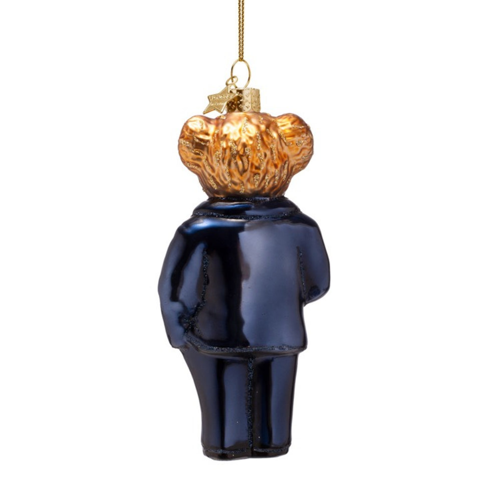 Decorative glass ornament of a bear in a blue suit with a gold top hat on a white background