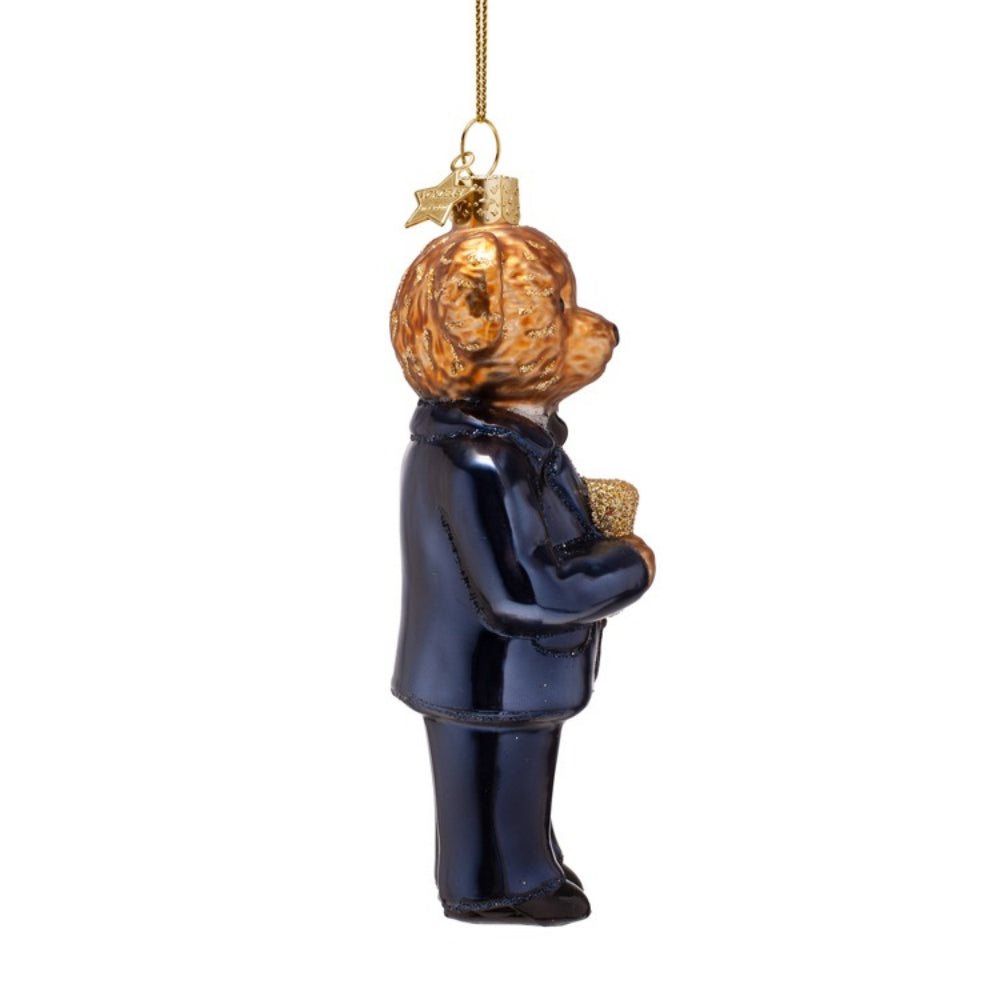 Glass ornament of a bear in a suit holding a gift, hanging on a white background