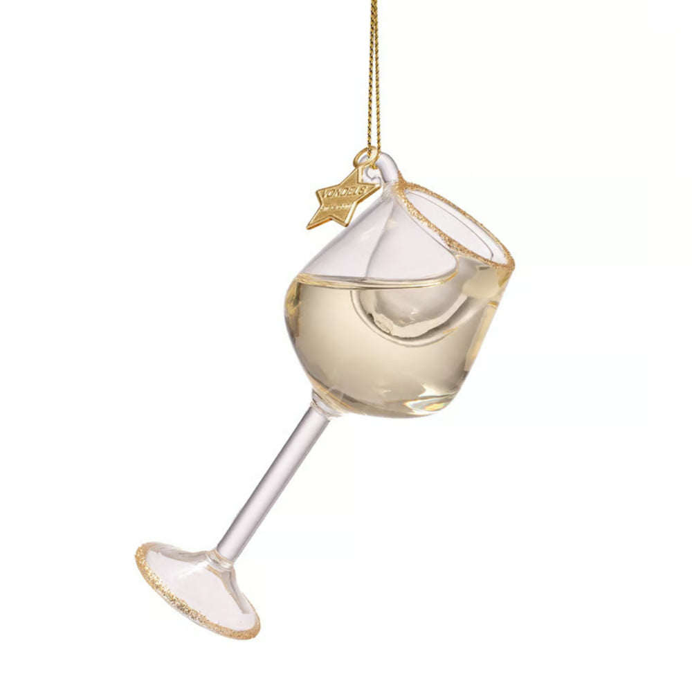 A clear glass wine glass ornament filled with pale gold liquid, hanging by a gold string with a small gold star charm that reads 'Paisley'.