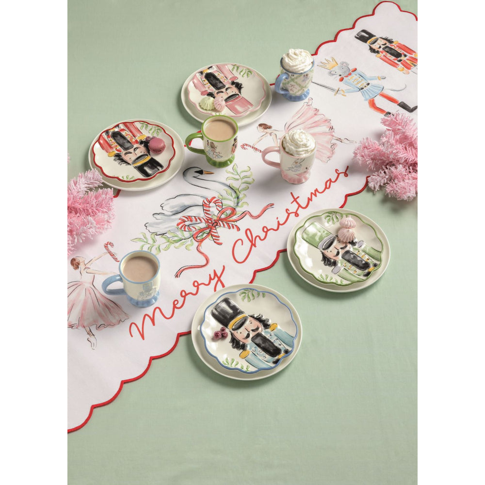 Decorative Christmas table setting with plates, cups, and a 'Merry Christmas' placemat.