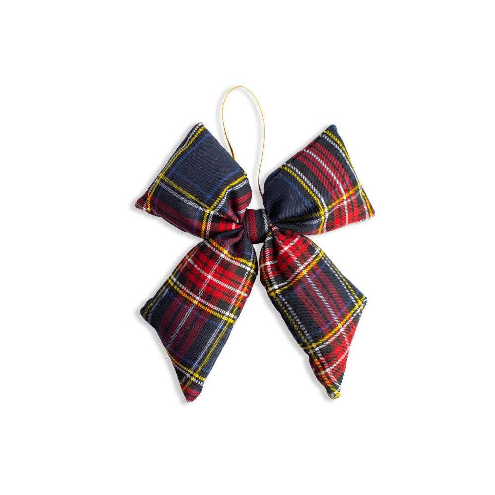 A fabric bow ornament in a red, navy, yellow, and white tartan plaid pattern, suspended by a thin gold string against a plain white background.