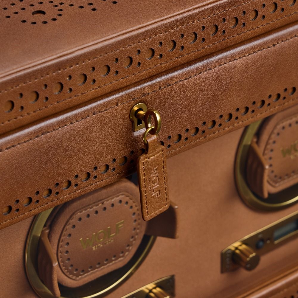 close up of brown watch winder key with WOLF written on it