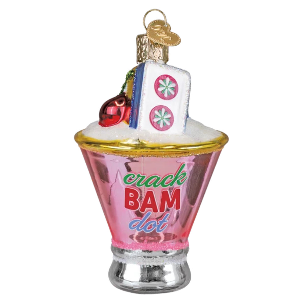 Decorative glass ornament resembling a pink and gold cocktail glass with 'crack BAM dot' text on a white background.