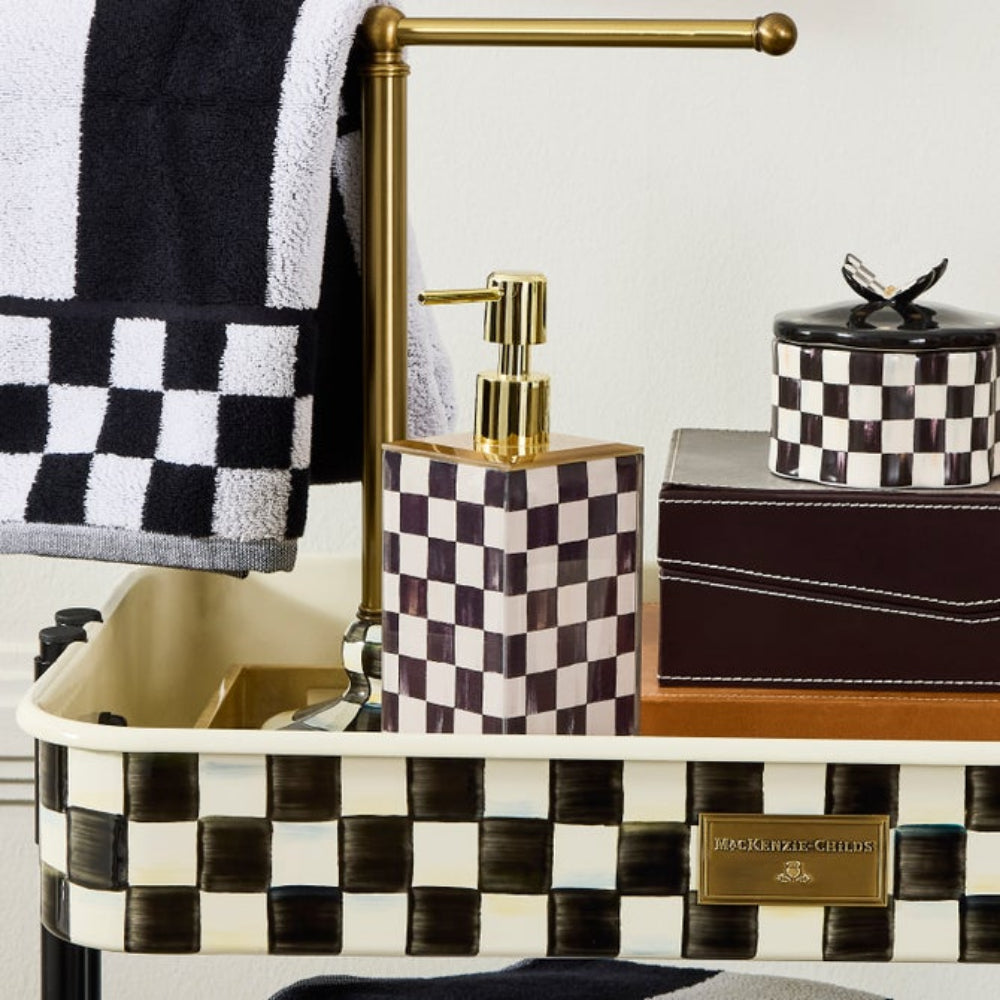 Bathroom setting with checkered sink, soap dispenser, and towel.
