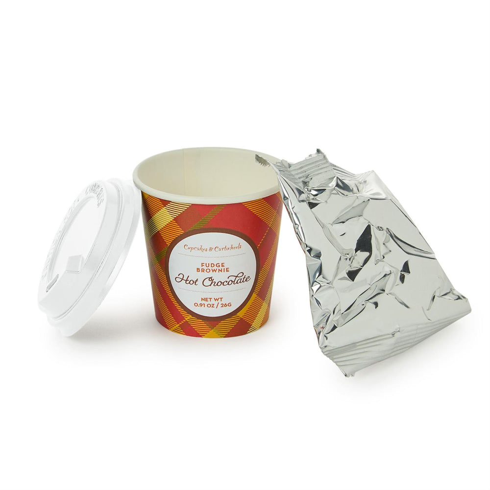 Cup of hot chocolate with a plaid design, surrounded by crumpled foil on a white background