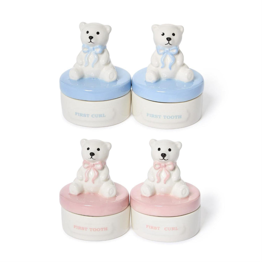 Four small ceramic keepsake jars shaped like polar bear cubs sitting on round bases, shown in two pairs with blue lids and two pairs with pink lids on a white background.