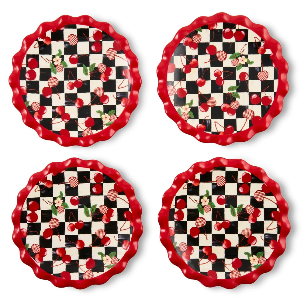 Four appetizer plates arranged in a 2x2 grid, featuring a red scalloped rim, a black and white checkerboard center, and a cherry and strawberry pattern.