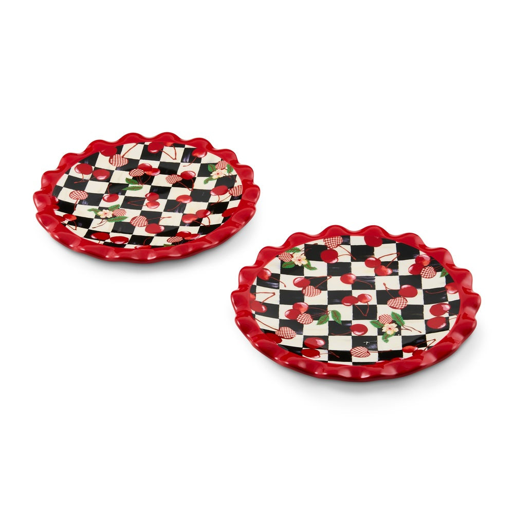 Two scalloped appetizer plates with a red and black checkerboard pattern and red cherries, shown on a white background.