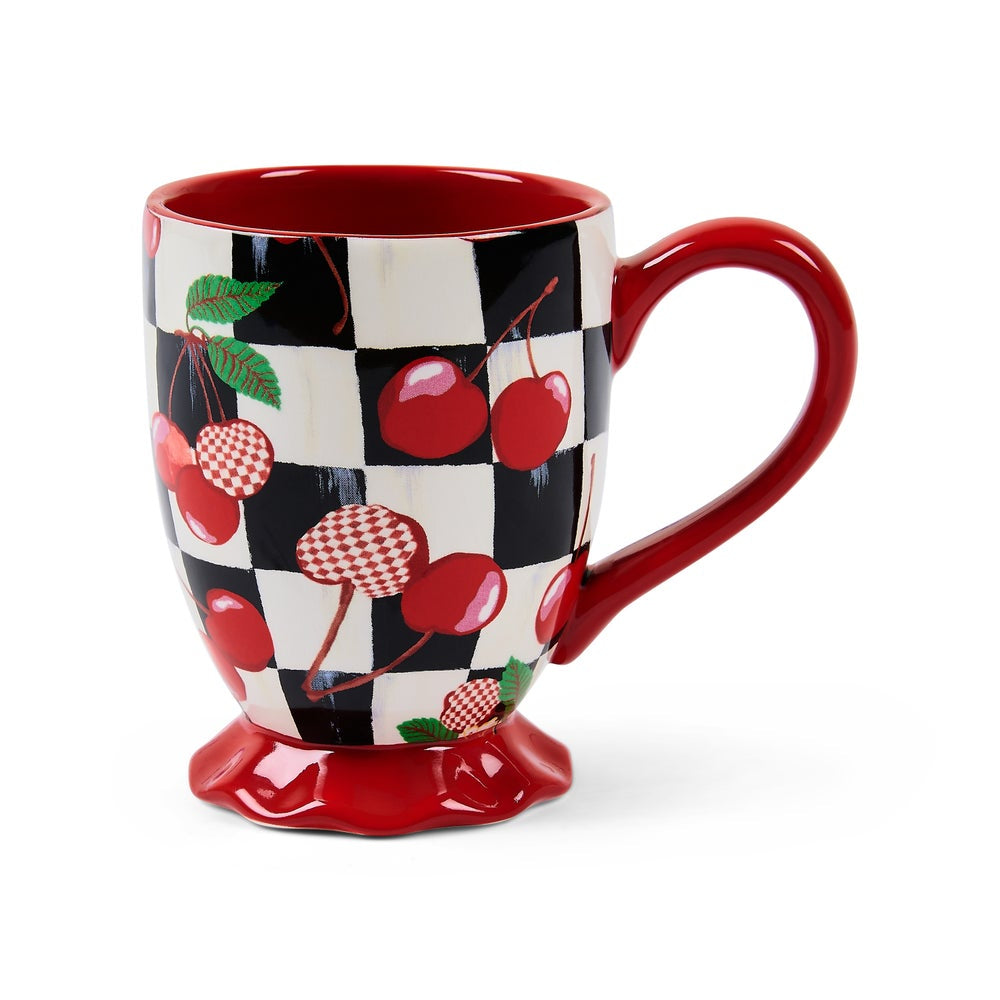 A ceramic coffee mug with a glossy red handle, base, and interior, decorated with a black and white checkerboard pattern and red cherries with green leaves on a white background.