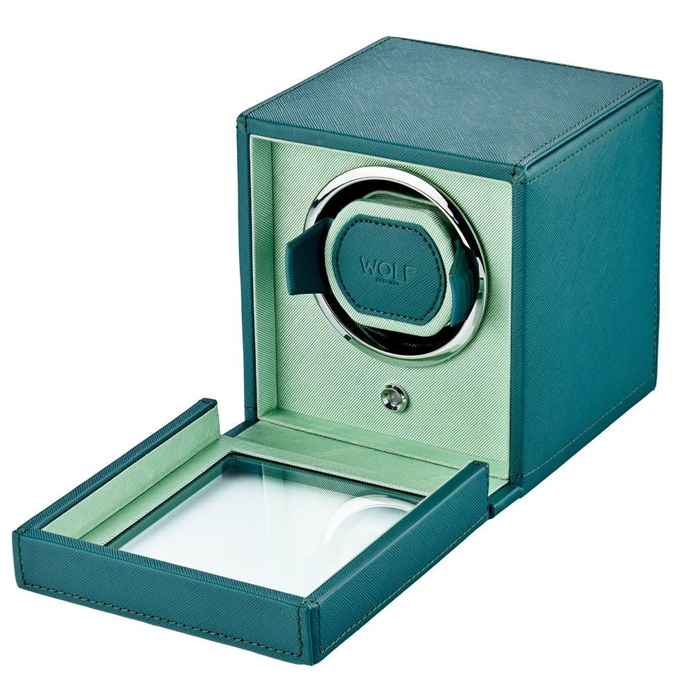 Teal watch winder with glass cover on a white background