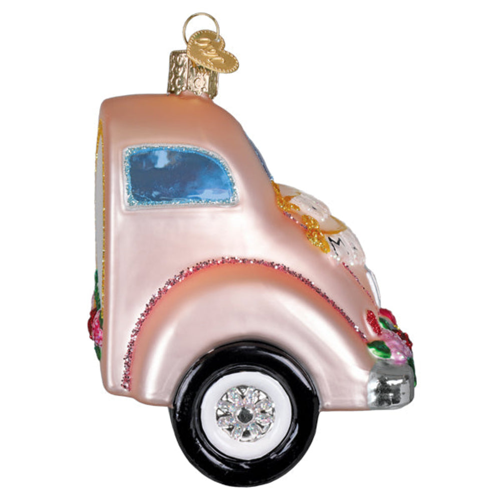 Decorative pink car ornament with floral details on a white background