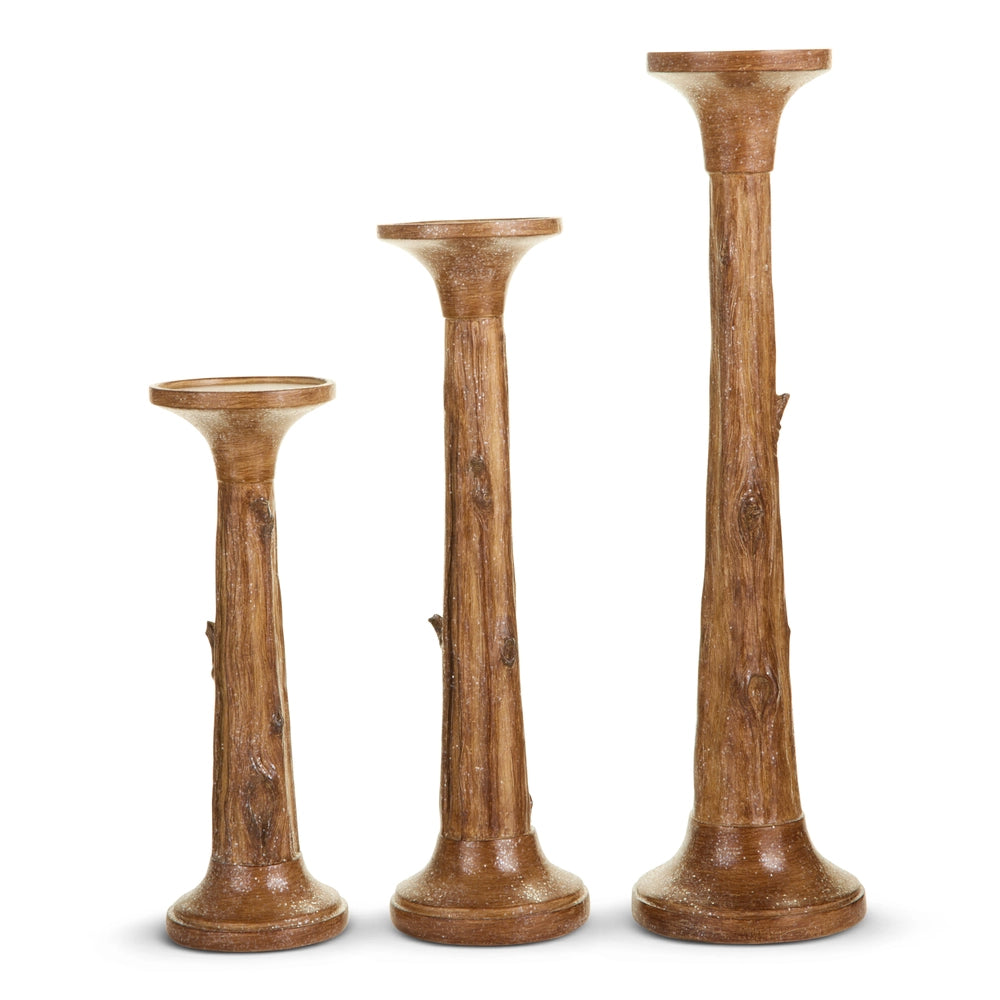 Three wooden candle holders of different heights on a white background