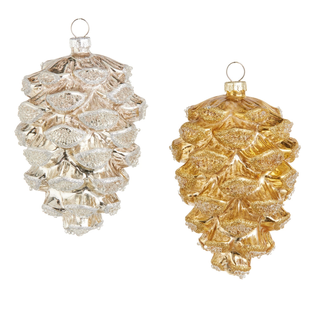 Two glass pine cone ornaments, one silver and one gold, on a white background.
