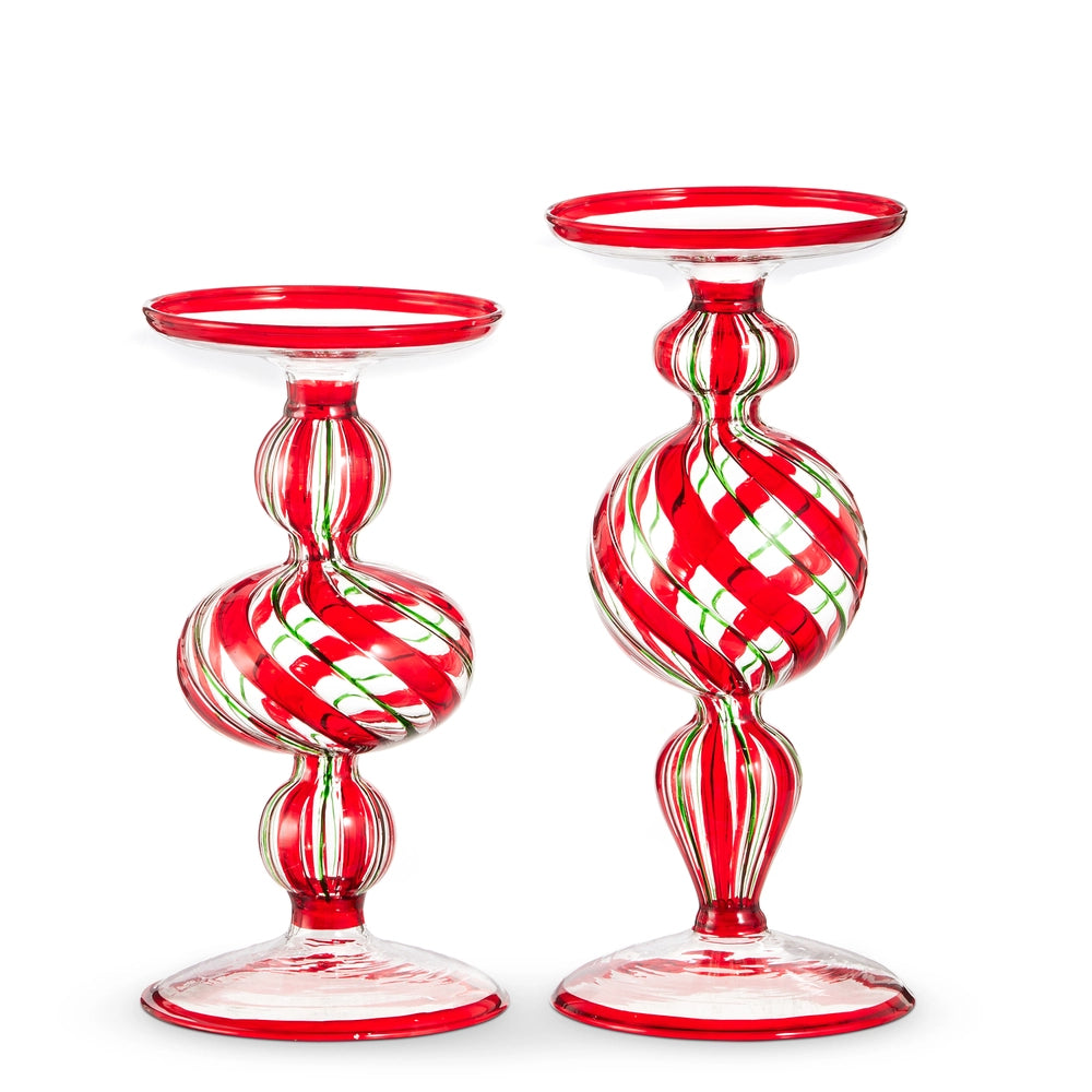 Two red and green glass candle holders on a white background