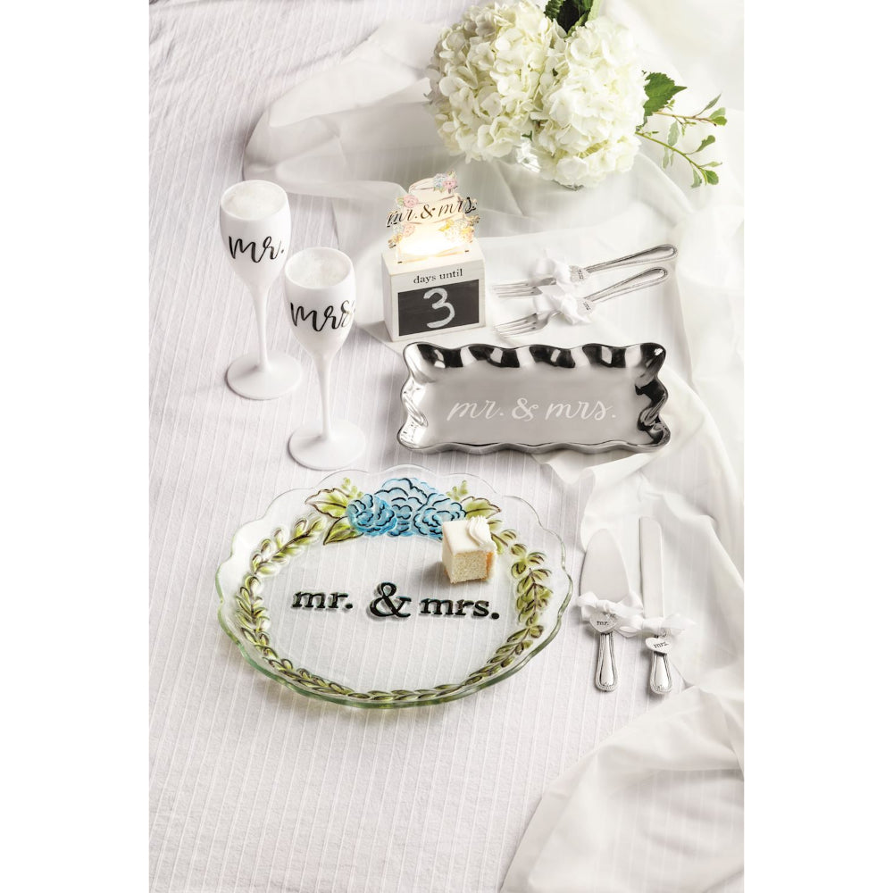 A styled wedding table setting on a white tablecloth featuring matching 'mr. & mrs.