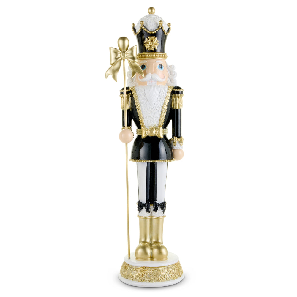 Decorative nutcracker figure with gold, black, and white attire on a white background