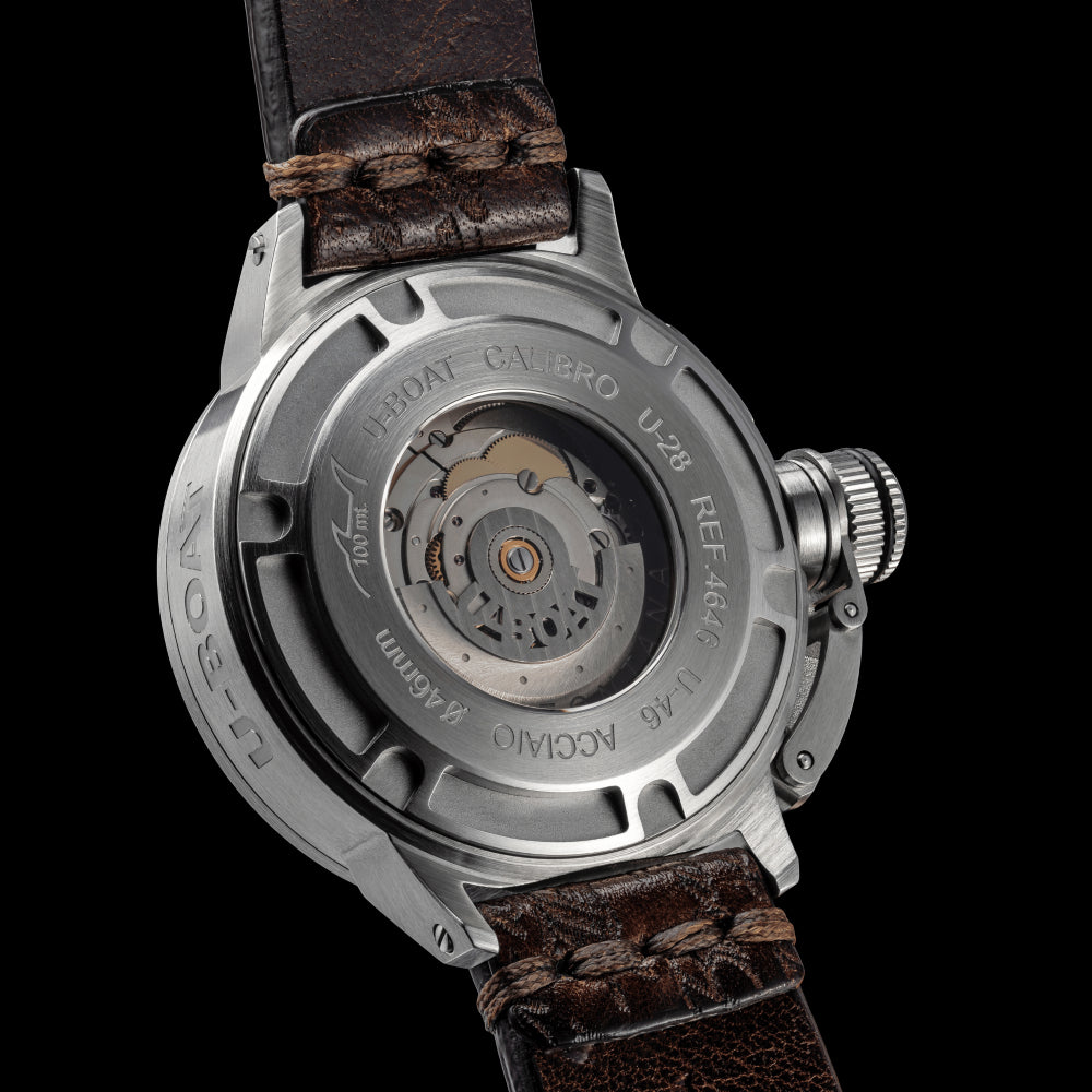 Watch with brown leather strap and metallic case on a black background