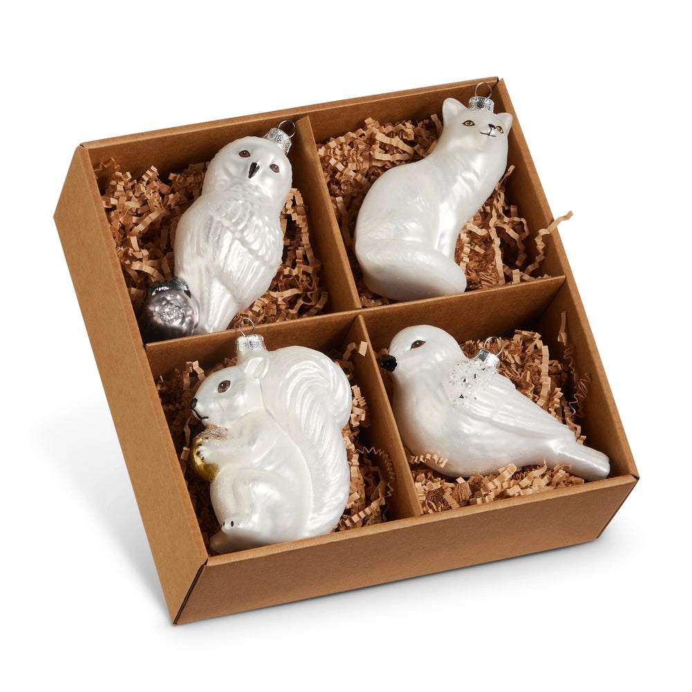 Set of four white ceramic animal ornaments in a brown box with straw-like filler.