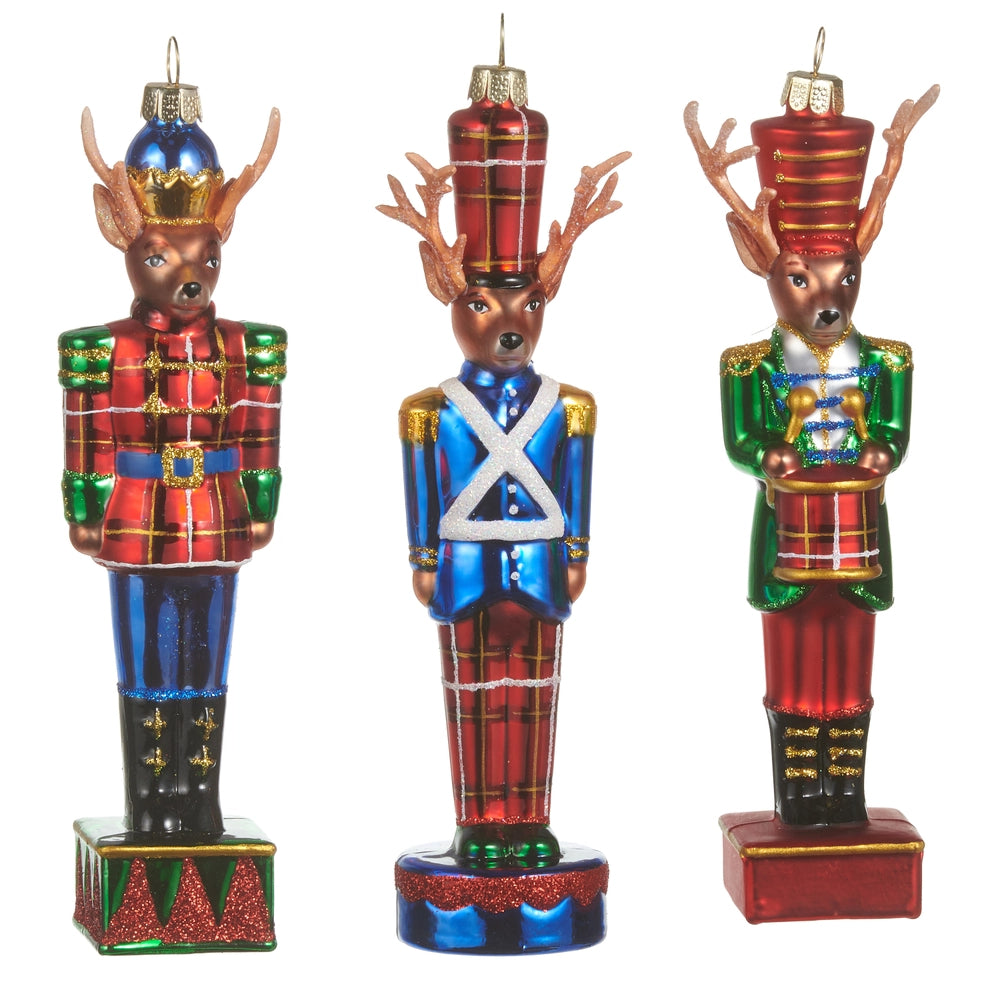 Three decorative deer ornaments in plaid and Nutcracker costumes on a white background