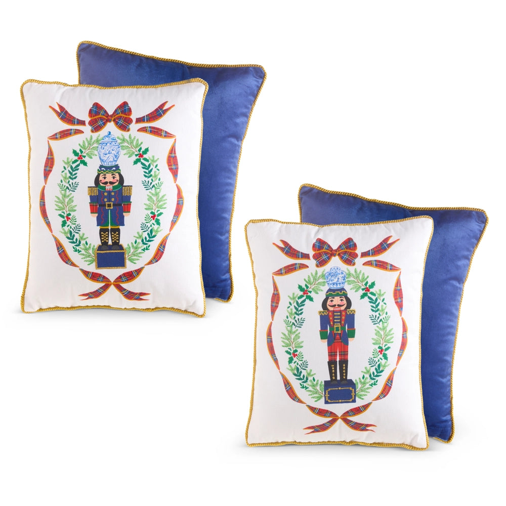 Two decorative pillows with nutcracker and wreath design on a white background