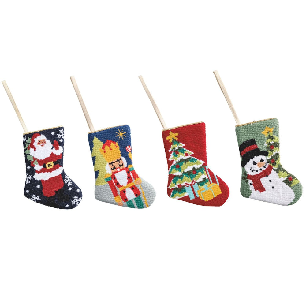 Four small Christmas stockings with festive designs on a white background