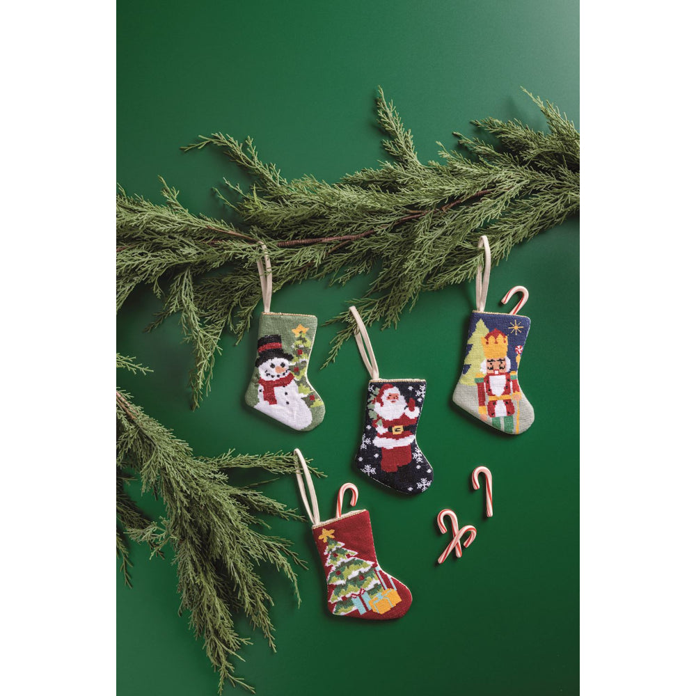 Set of Christmas-themed ornaments including stockings, candy canes, and a snowman on a green background.