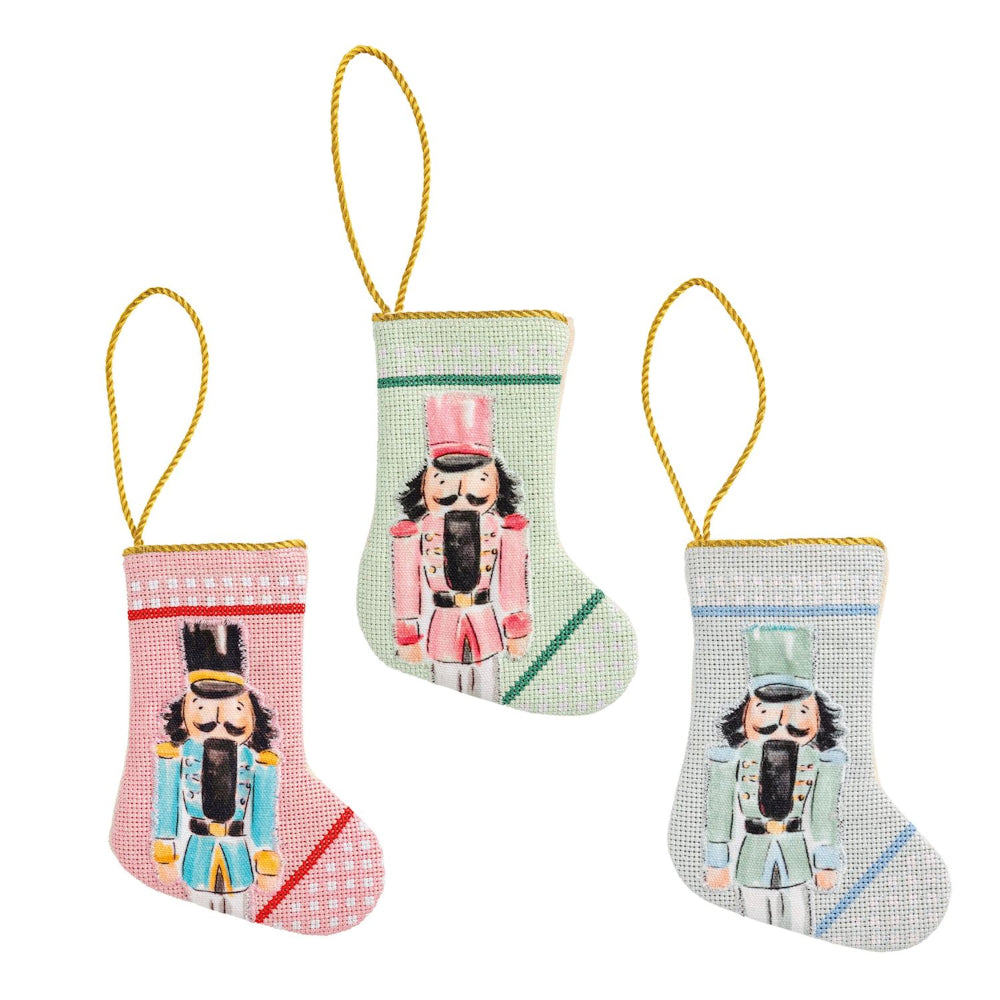 Three decorative Christmas stockings with nutcracker designs on a white background