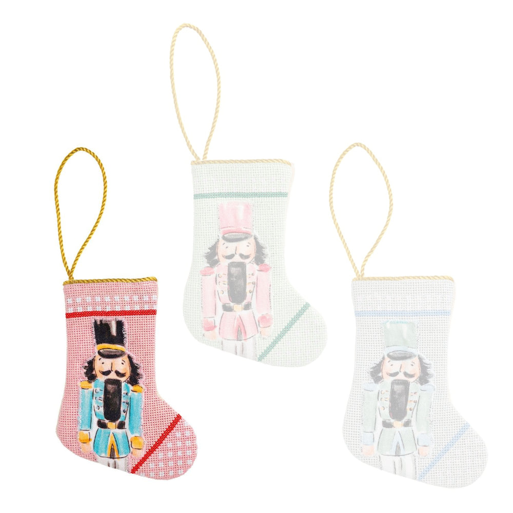 Three decorative Christmas stockings with nutcracker designs on a white background