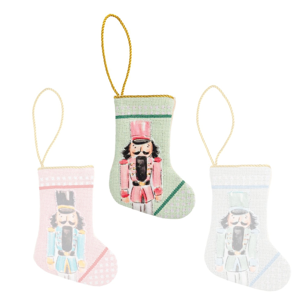 Three decorative Christmas stockings with nutcracker designs on a white background