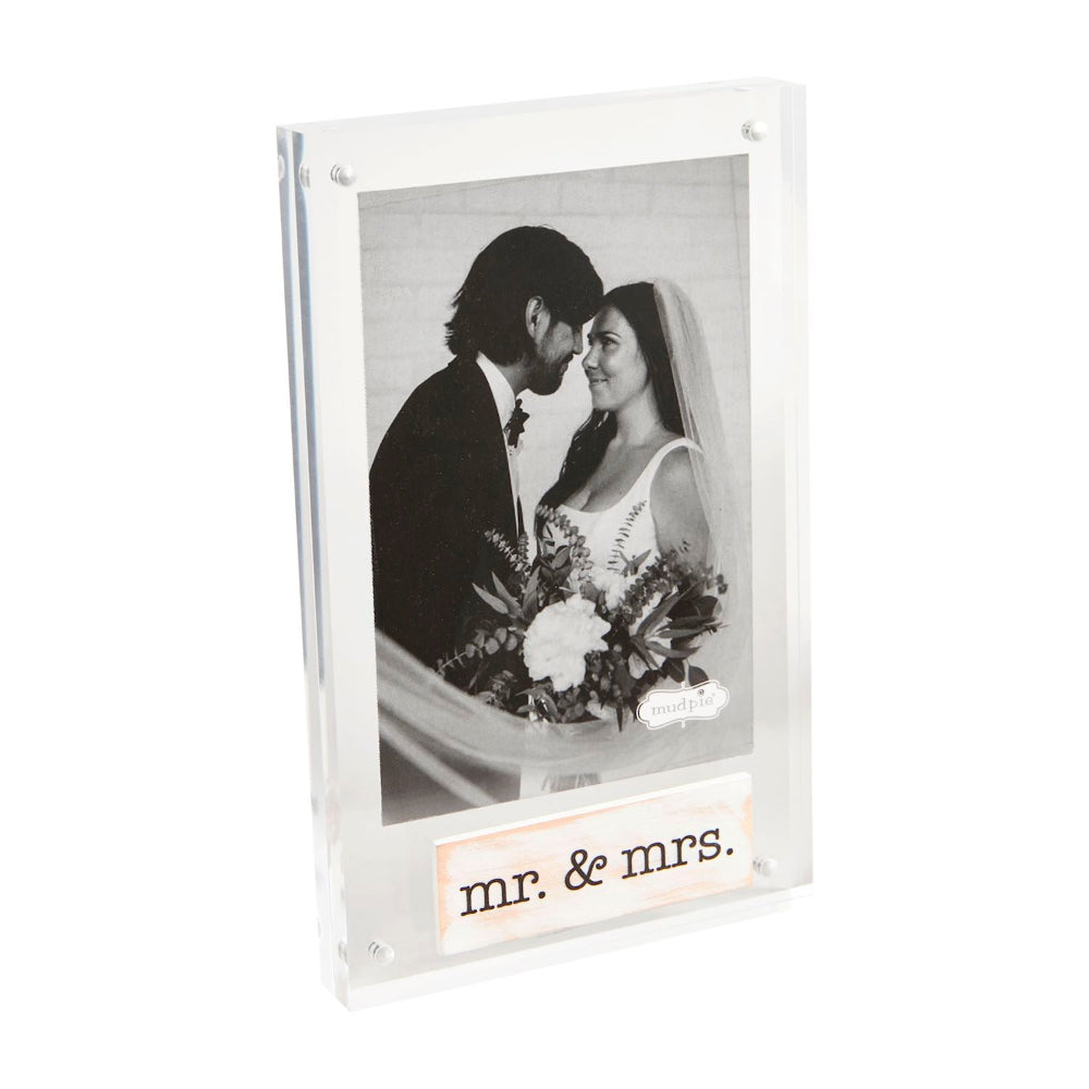 Clear acrylic photo frame with 'mr. & mrs.' text, holding a wedding photo of a couple.