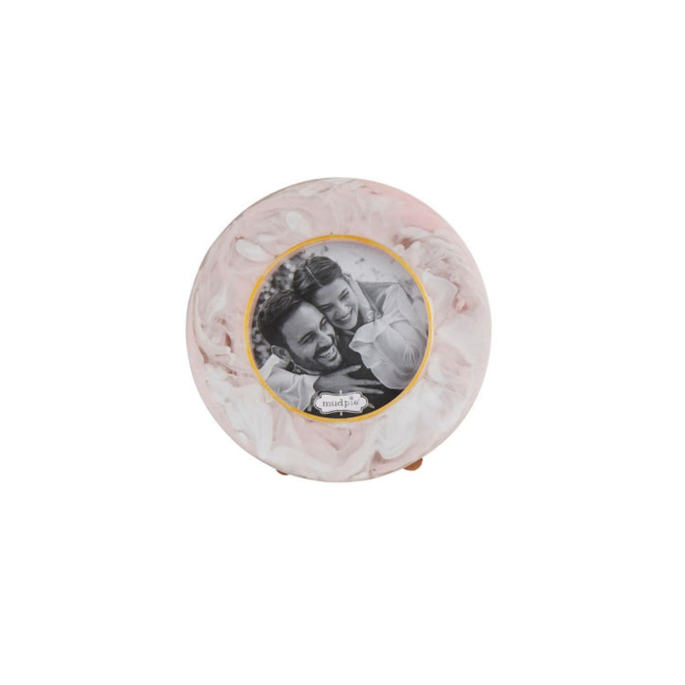 Pink round marble photo frame with a couple's photo inside on a white background.