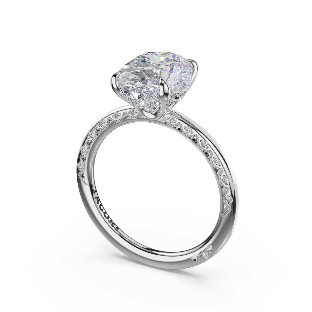 A silver-toned solitaire engagement ring featuring a large oval-cut clear gemstone in a prong setting, with a polished band accented by small pavé-set stones, shown on a white background.