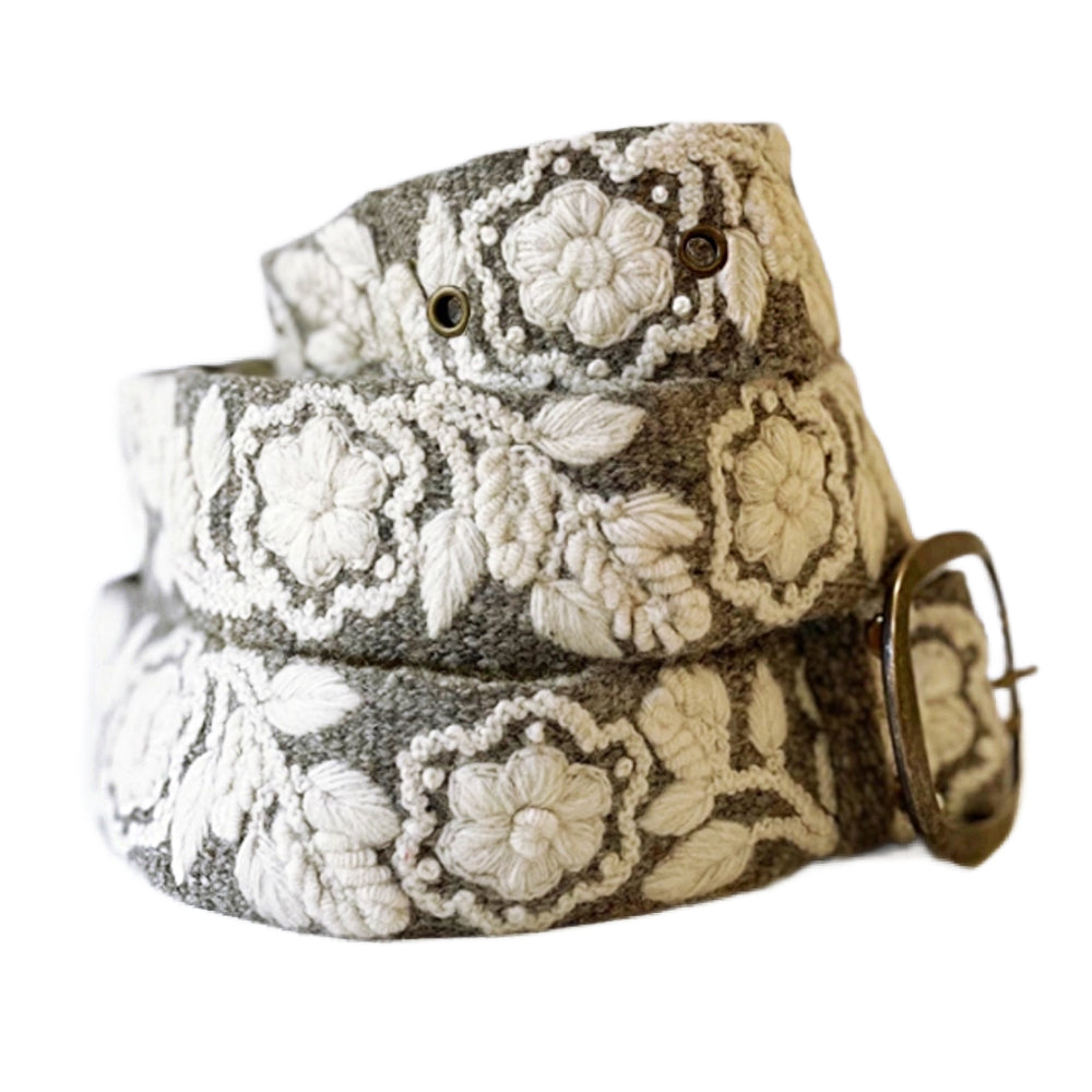 Floral patterned belt with a metallic buckle on a light background