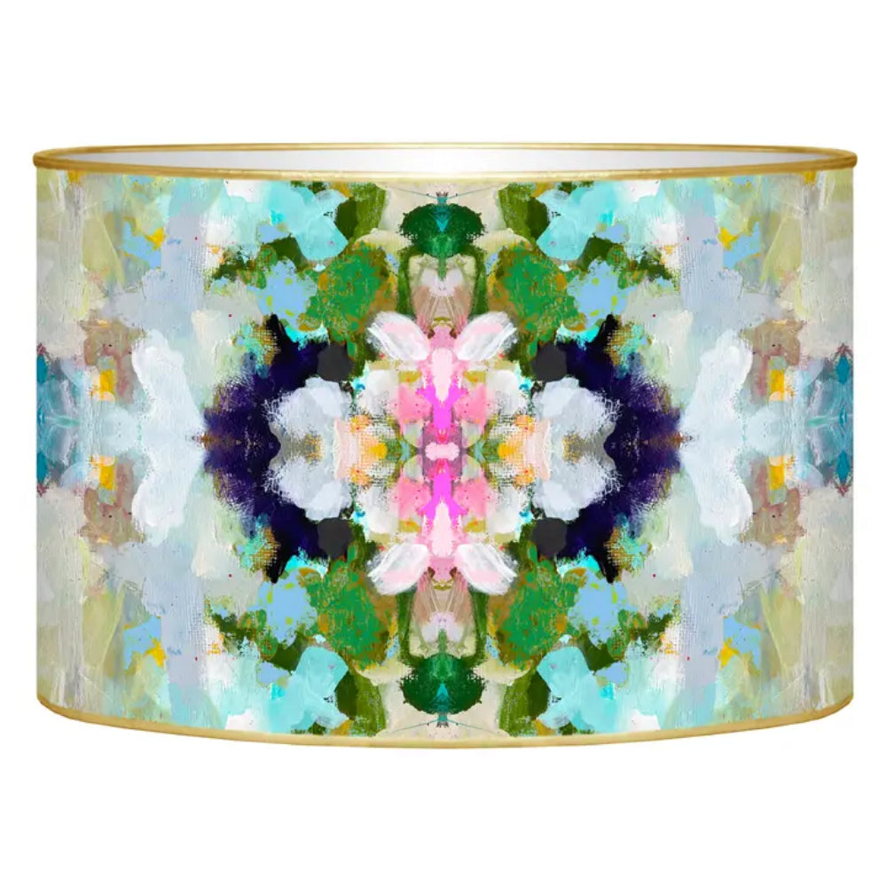 A cylindrical drum lampshade desk organizer featuring a symmetrical, kaleidoscopic abstract art print with green, pink, blue, and white paint splatters, finished with a thin gold metal rim at the top and bottom.