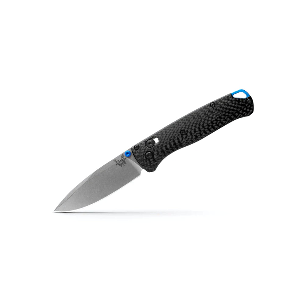 A folding pocket knife with a textured black carbon fiber handle and a silver steel blade, featuring small blue accents near the bolster and handle end, shown on a clean white background.