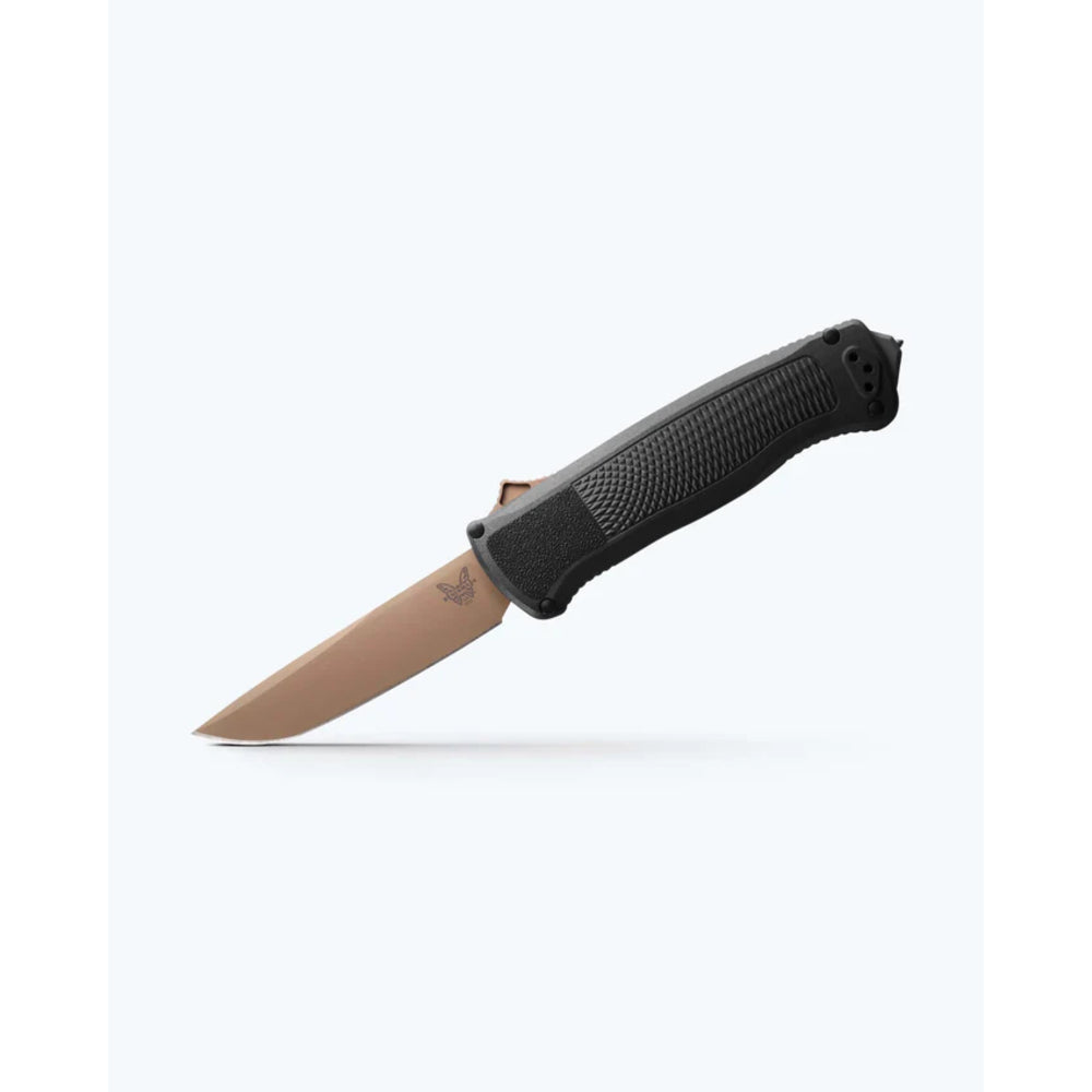 A tactical folding knife with a textured black handle and a matte tan blade, shown open against a clean white background.