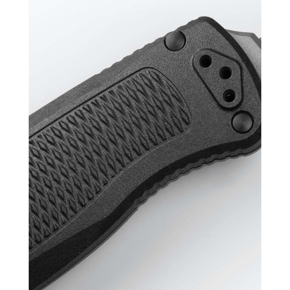 Close-up of a black folding knife handle showing textured grip, pocket clip area, and thumb stud on a white background.