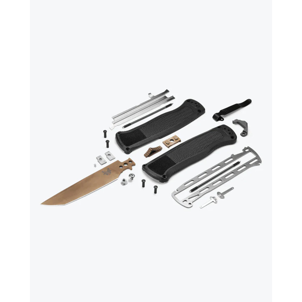 A disassembled knife shown with its components laid out on a light gray background, including a tan blade, black handle grips, silver metal bars, screws, and small hardware.