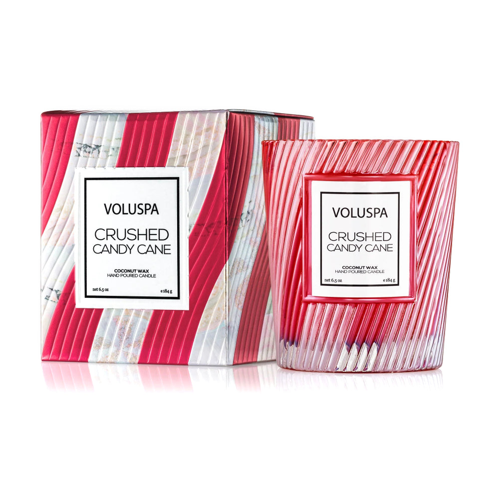 Voluspa Crushed Candy Cane scented candle shown with its matching box packaging on a clean white background. The candle is in a clear ribbed glass jar with red and white striped pattern, and the box features a similar red and white striped design with a white brand label.