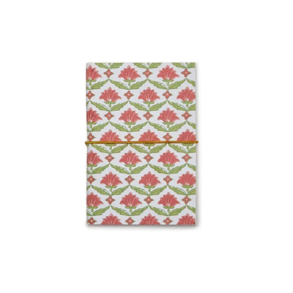 A notebook with a white cover featuring a repeating coral-pink floral and green leaf pattern, secured with a thin orange elastic band, shown against a plain white background.