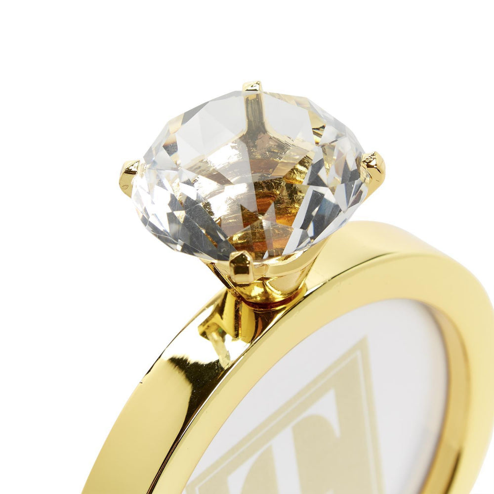 Top of a gold  3"x 3" diamond ring frame showing the diamond on top. 