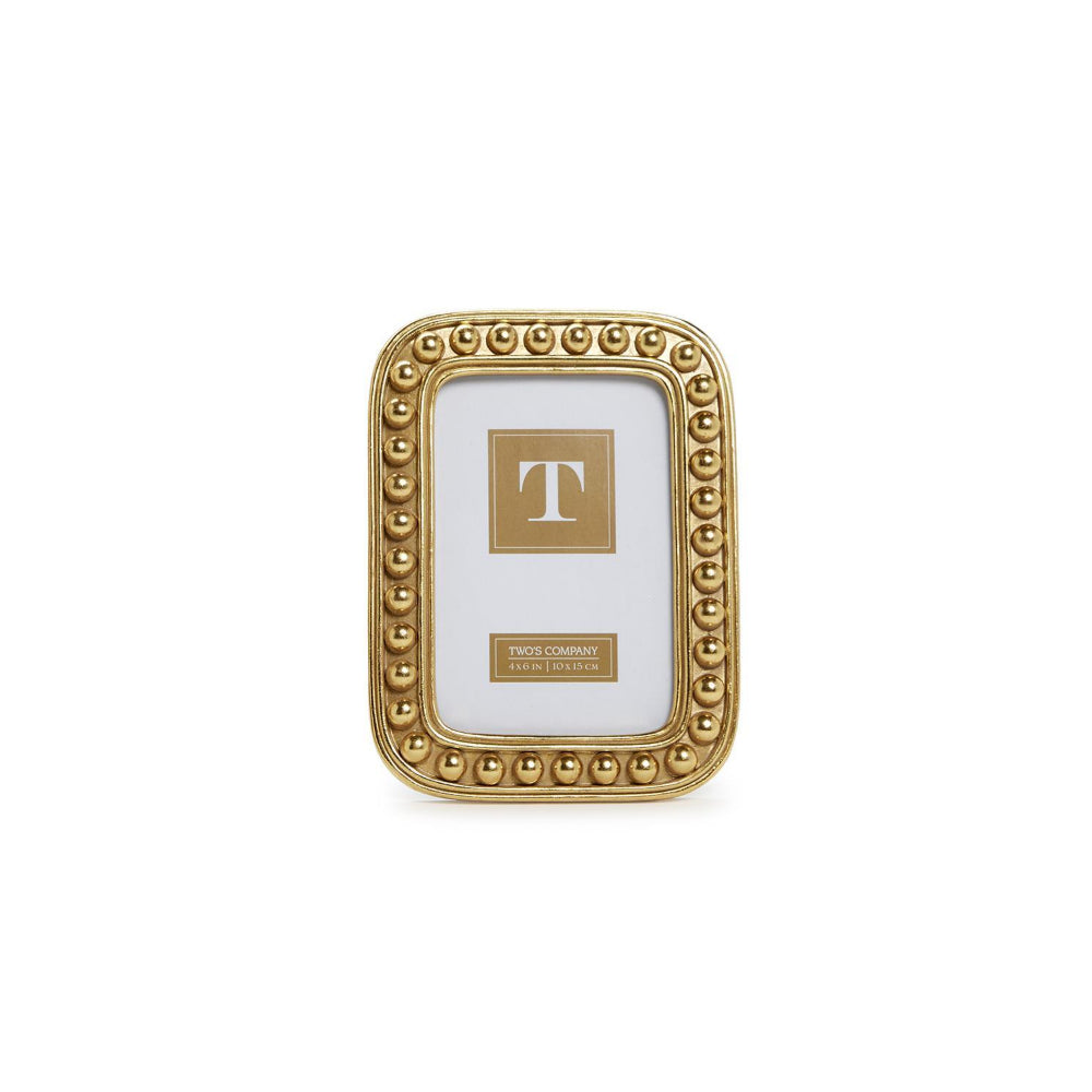 A 4x6 rectangular gold picture frame with a beaded border and a white insert card featuring a gold 'T' monogram and a small 'Twelve Hundred Design Studios' label, shown on a plain white background.