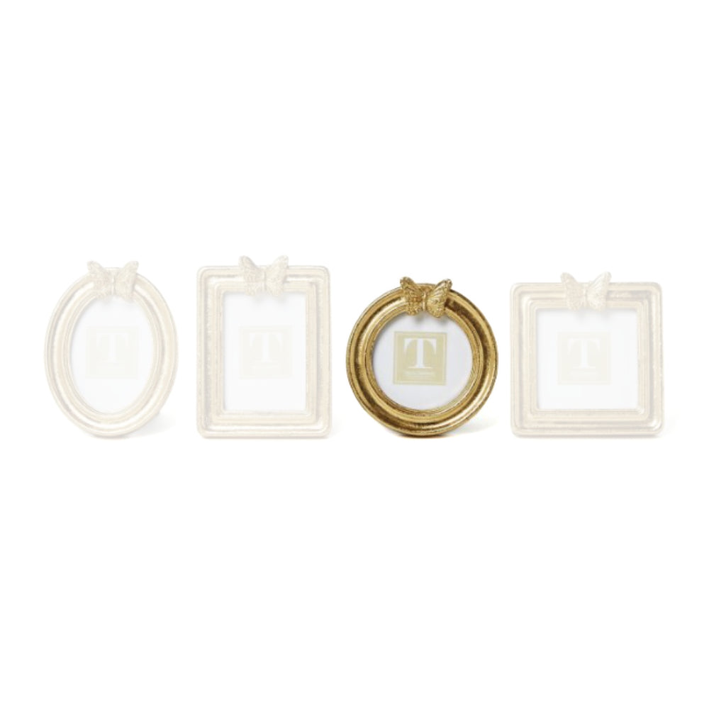 Round gold picture frame with a  decorative butterfly on top on a white background.