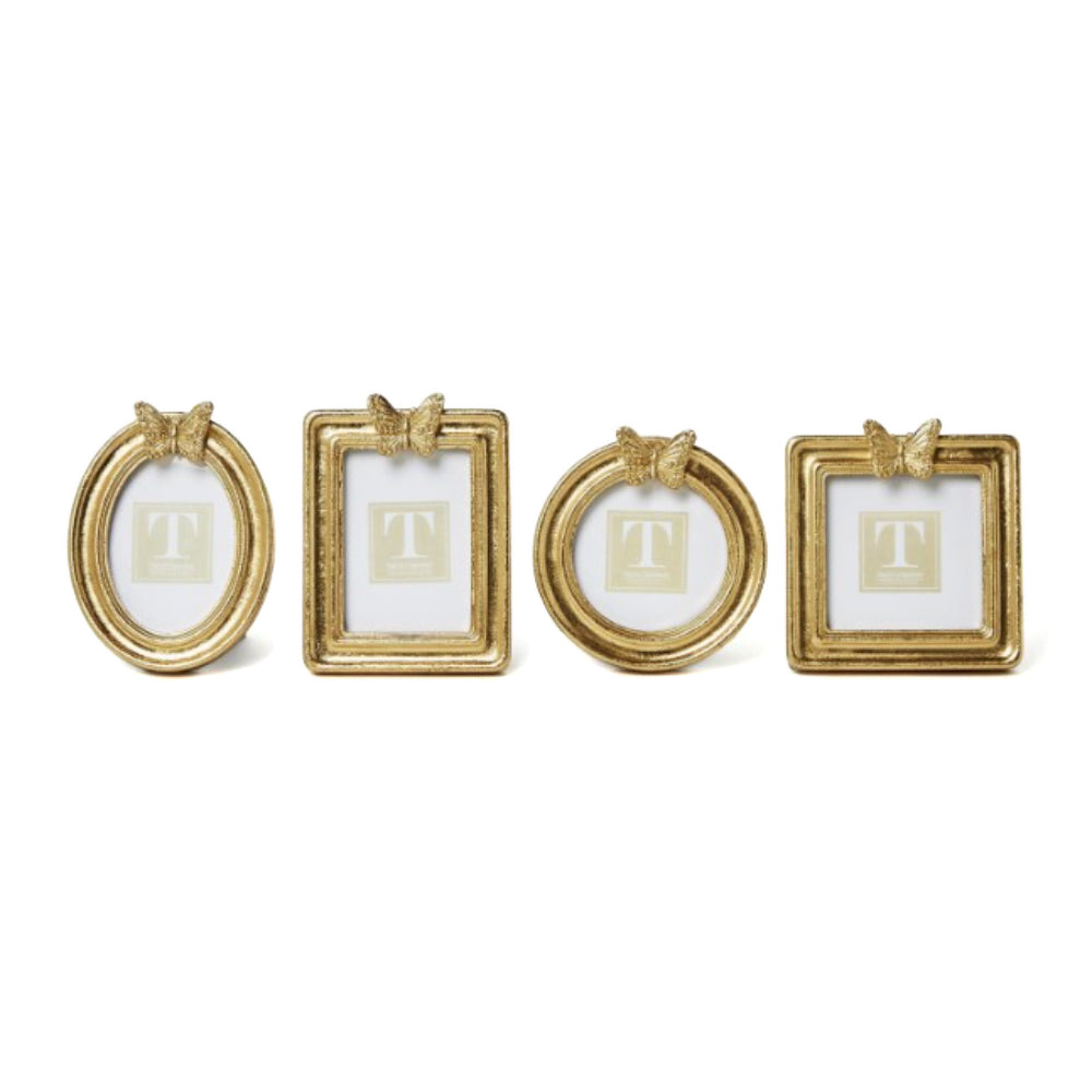 Four gold picture frames in differant shapes with a  decorative butterfly on top on a white background.