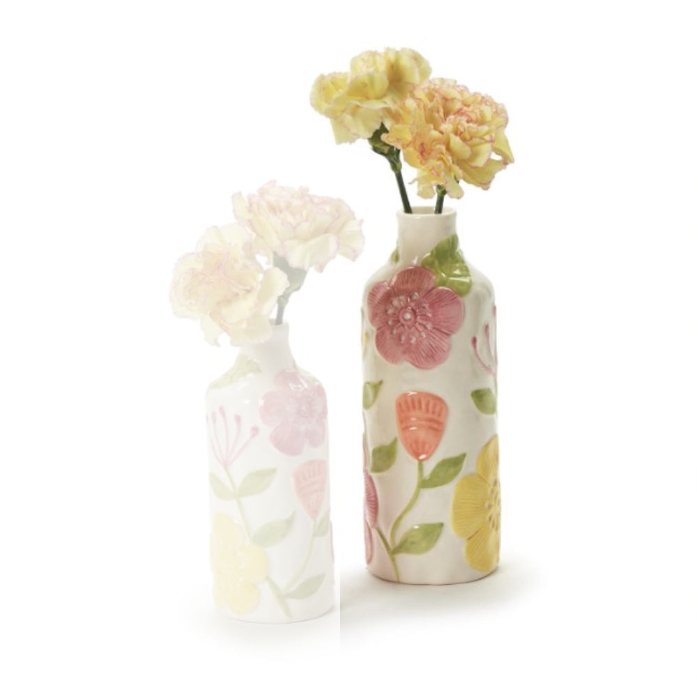 Two small ceramic flower vases with a white base and colorful floral patterns, one holding pale pink flowers and the other holding pale yellow flowers, on a white background.