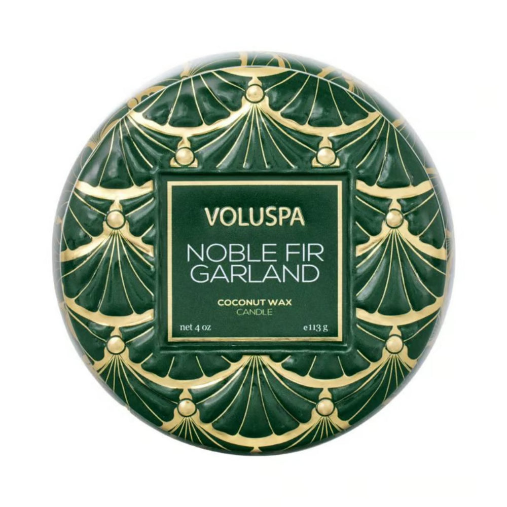 Top of a green tin candle with gold decorative pattern on a white background.